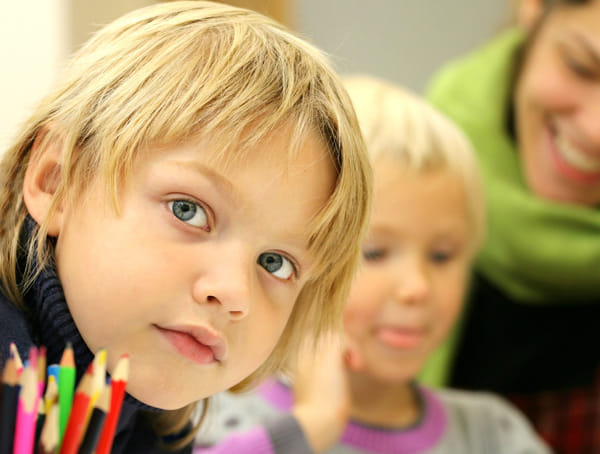 Nachhilfe Schüler und Schülerin Nahaufnahme und Nachhilfelehrer im Hintergrund